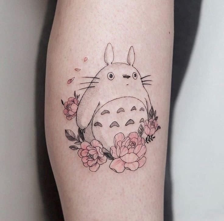 Tatuaje de anime acompañado de flores.