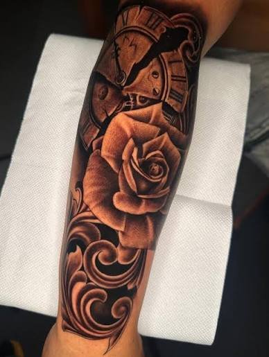Tatuaje Chicano de rosa y reloj realizado en negro y gris.