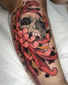 Tatuaje neotradicional de calavera acompañada de rosas y elementos decorativos.