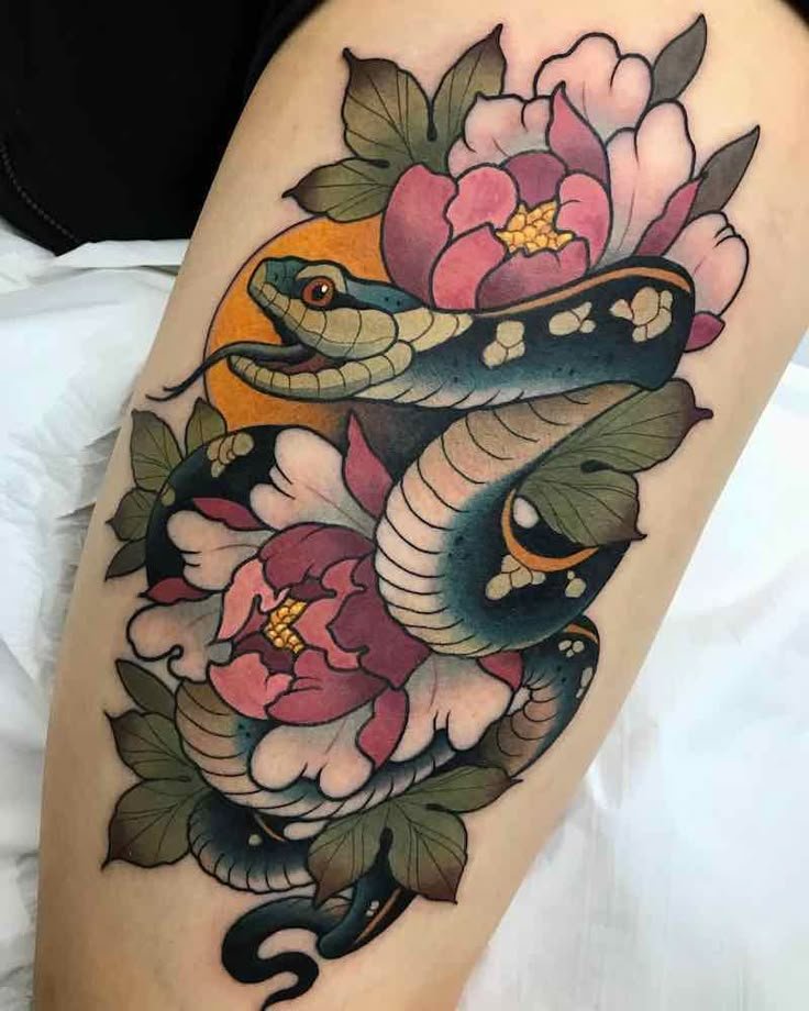 Tatuaje neotradicional de serpiente entre peonías de colores intensos.