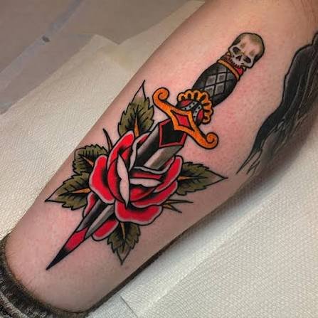 Tatuaje tradicional de daga atravesando una rosa.